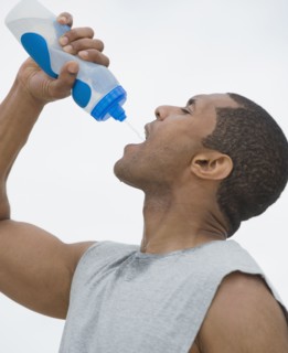 African man drinking from water bottle
