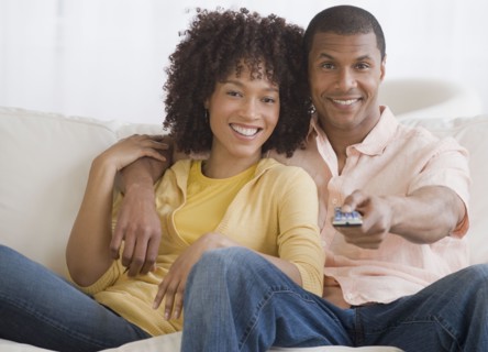 African couple watching television