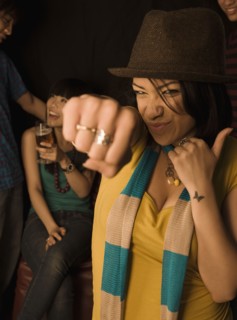 Mixed race woman punching air in nightclub