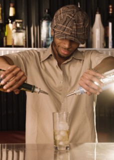 African bartender pouring a mixed drink