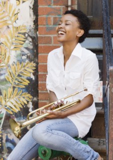 African woman holding trumpet outdoors