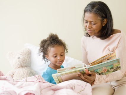African grandmother reading granddaughter a bedtime story