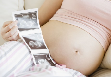 Pregnant Asian woman looking at ultra sound pictures