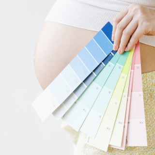 Pregnant Asian woman holding several color swatches