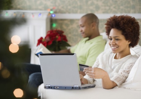 Mixed race woman buying Christmas presents online with credit card