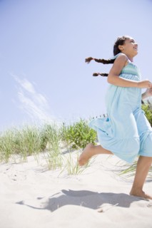 Hispanic girl running at beach