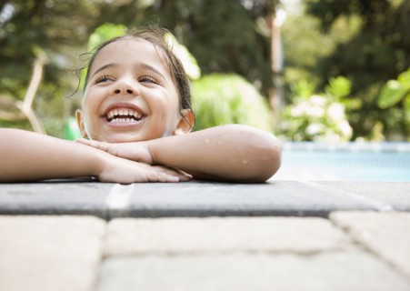 Hispanic girl resting at poolside