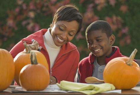 African mother and son carving pumpkins