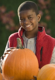African boy holding pumpkin