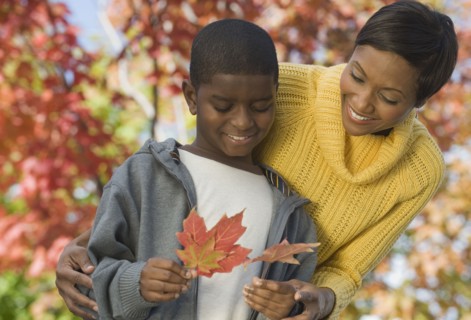 African mother and son looking at autumn leaves