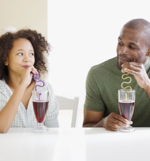 African father and daughter drinking with straws