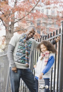 African father and daughter near fence