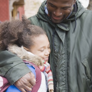 African father hugging daughter