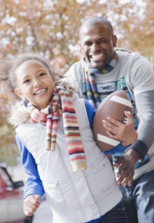 African father and daughter playing football