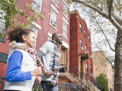African father and daughter running in city