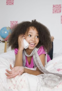 African girl using telephone on bed