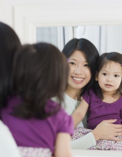Mother and daughter looking in mirror