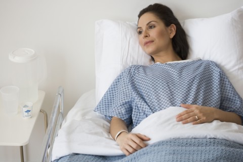 Hispanic woman laying in hospital bed