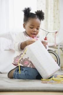 African American girl opening birthday gift