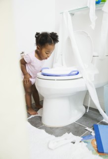 African American girl looking into toilet