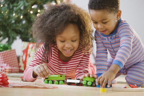 African American brother and sister playing with toy train