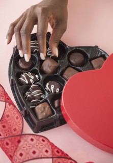 African woman taking chocolates from Valentines box