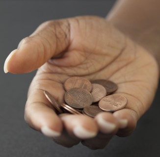 African woman holding handful of pennies