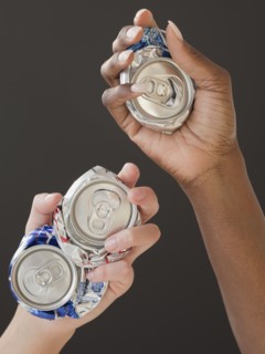 African and Caucasian woman holding crushed cans