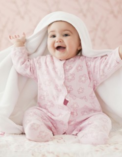 Mixed race baby girl playing peek-a-boo under blanket
