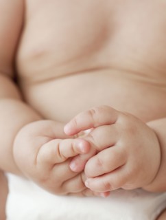 Close up of mixed race baby girl with hands clasped