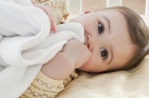 Mixed race baby girl laying in crib