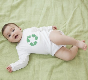 Mixed race baby girl with recycling symbol on shirt