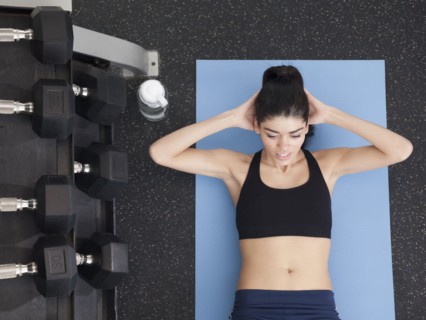 Hispanic woman doing sit-ups in health club