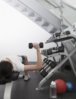 Hispanic woman using hand weights in health club