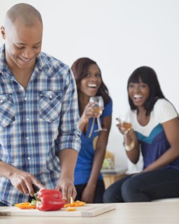 African man preparing dinner for friends