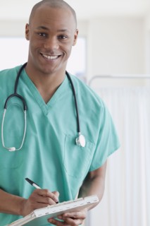African doctor writing in medical chart