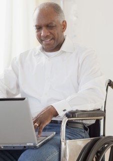 African man in wheelchair using laptop
