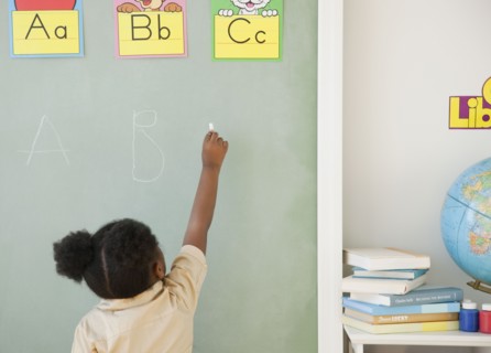 African girl writing on blackboard