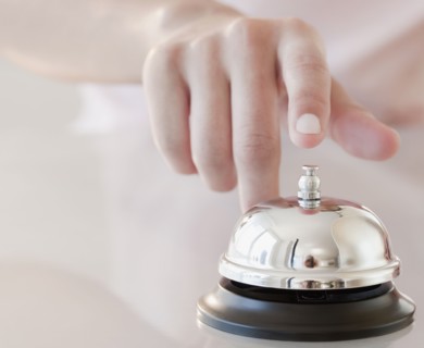 Woman tapping hotel service bell