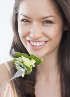 Mixed race woman eating salad