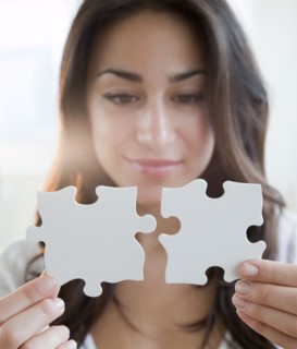 Hispanic woman holding two puzzle pieces
