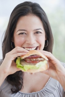 Hispanic woman eating hamburger