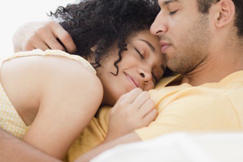 Couple cuddling on bed