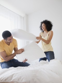 Couple pillow fighting on bed