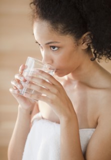 Mixed race woman drinking water