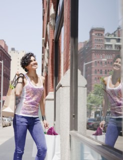 Mixed race woman window shopping on urban street