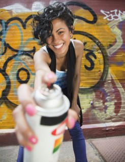 Mixed race graffiti artist holding spray paint can