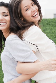 Friends linking arms back to back