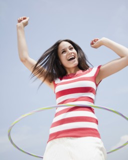 Mixed race woman spinning plastic hoop