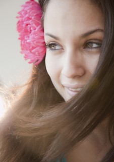 Mixed race woman with flower in hear